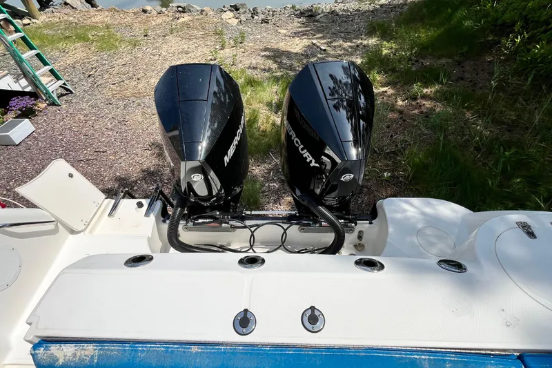 Slide: The Image of Twin Mercury outboard engines on a 2006 Boston Whaler 285 Conquest boat, docked onshore. - 15