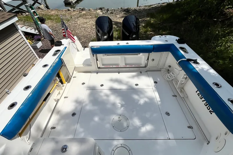 Slide: The Image of 2006 Boston Whaler 285 Conquest boat deck with blue seating and twin Mercury engines. - 19