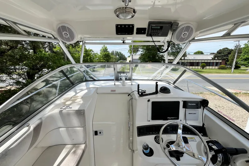 Slide: The Image of 2006 Boston Whaler 285 Conquest helm with steering wheel, navigation equipment, and seating. - 26