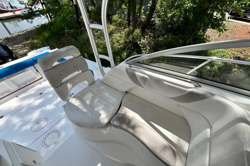 Slide: The Image of 2006 Boston Whaler 285 Conquest boat interior with seating and helm, docked near water. - 28