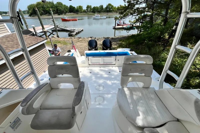 Slide: The Image of 2006 Boston Whaler 285 Conquest boat docked by a serene lakeside with lush greenery. - 31