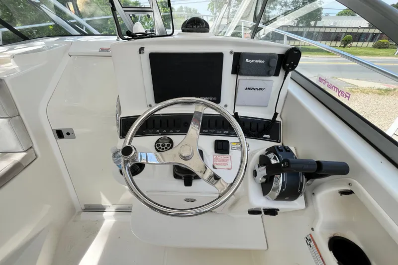 Slide: The Image of Helm of 2006 Boston Whaler 285 Conquest with steering wheel and navigation controls. - 32