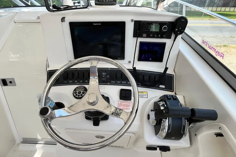 Slide: The Image of Control panel of a 2006 Boston Whaler 285 Conquest boat with steering wheel and navigation equipment. - 33