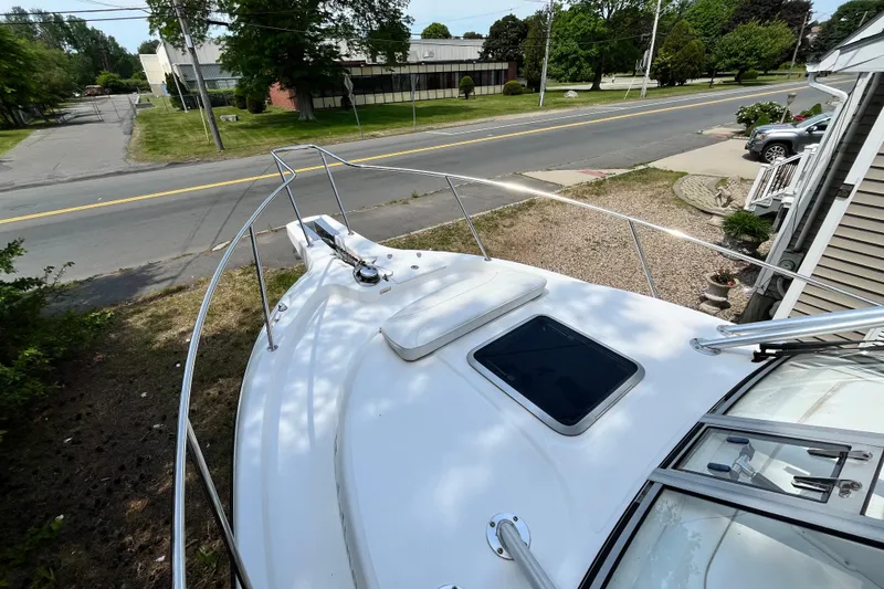 Slide: The Image of 2006 Boston Whaler 285 Conquest boat docked near a suburban street. - 41