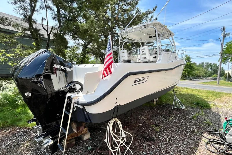 Slide: The Image of 2006 Boston Whaler 285 Conquest boat with Mercury engine, displayed outdoors with American flag. - 7