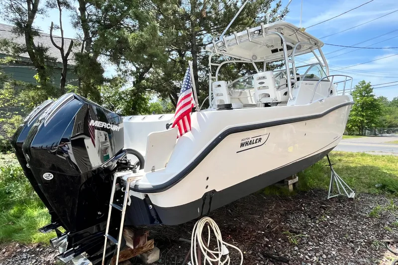 Slide: The Image of 2006 Boston Whaler 285 Conquest boat with Mercury engine, displayed outdoors. - 8