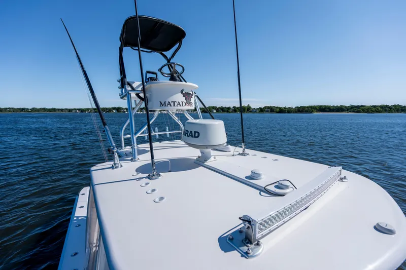 Slide: The Image of 2015 Contender 39 ST boat on calm water under clear blue sky. - 12