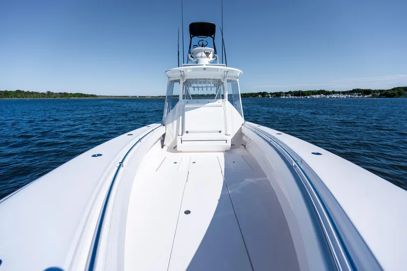 Slide: The Image of 2015 Contender 39 ST boat on open water, clear sky, and distant shoreline. - 19