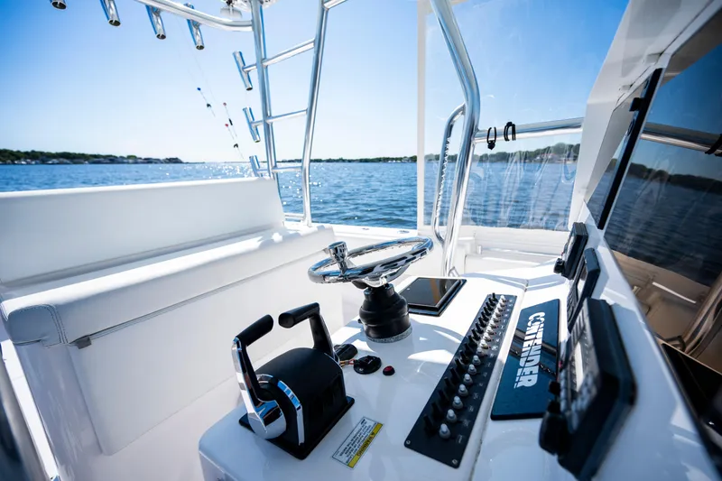 Slide: The Image of 2015 Contender 39 ST boat cockpit with steering wheel and control panel on open water. - 26