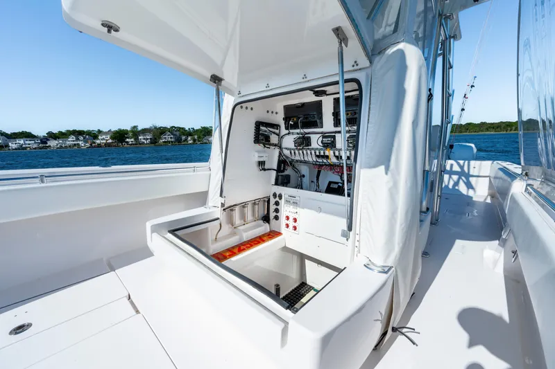 Slide: The Image of 2015 Contender 39 ST boat with open console, showcasing interior electronics and wiring by the water. - 28