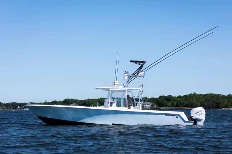 Slide: The Image of 2015 Contender 39 ST boat on water, featuring sleek design and powerful outboard engines. - 3