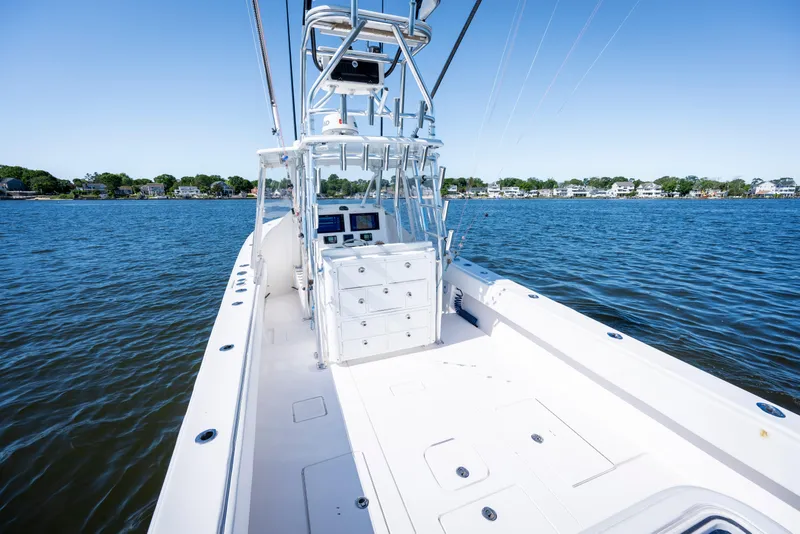 Slide: The Image of 2015 Contender 39 ST boat on calm water, clear sky, coastal background. - 31