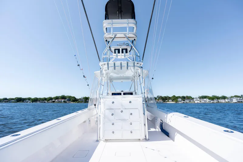Slide: The Image of 2015 Contender 39 ST boat on calm water, clear sky, coastal background. - 32