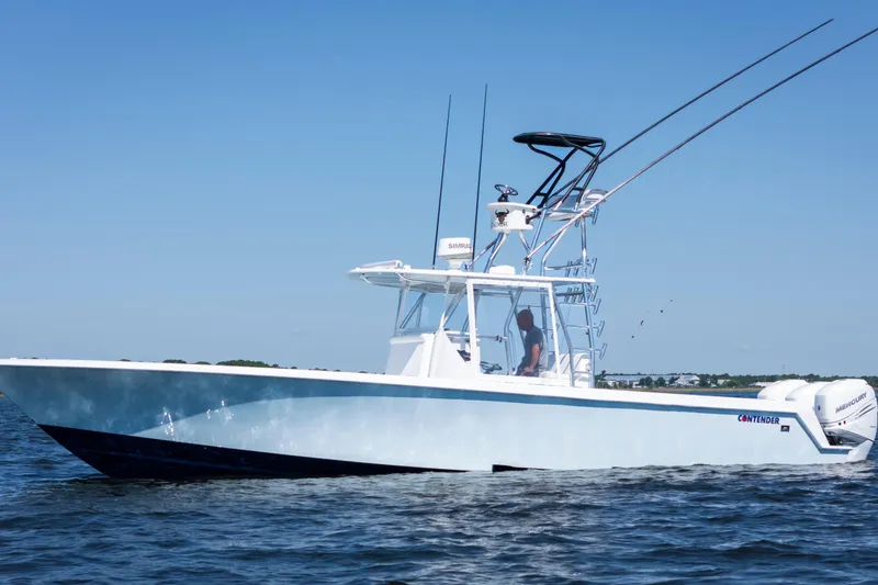 Slide: The Image of 2015 Contender 39 ST boat on water, clear sky, equipped with fishing rods. - 4