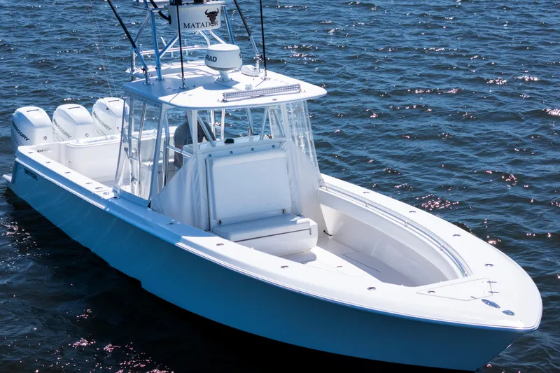 Slide: The Image of 2015 Contender 39 ST boat on water, featuring sleek design and triple outboard engines. - 5