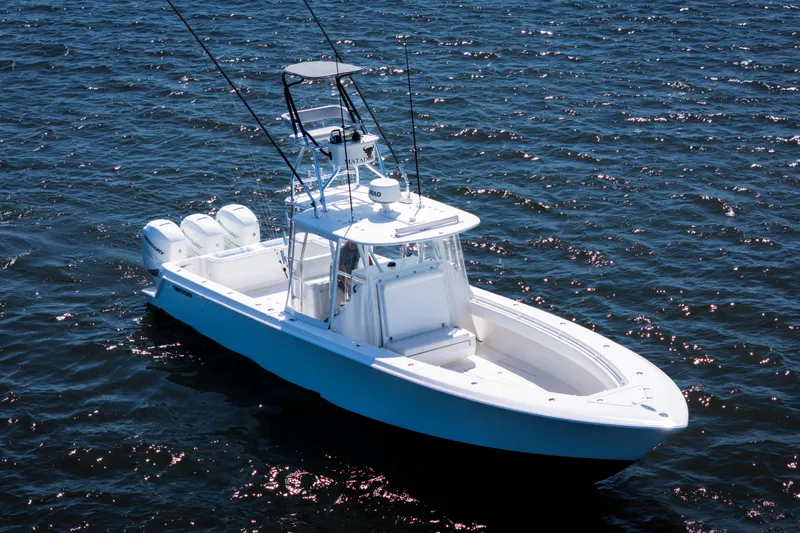 Slide: The Image of 2015 Contender 39 ST boat on open water, featuring triple outboard engines. - 6