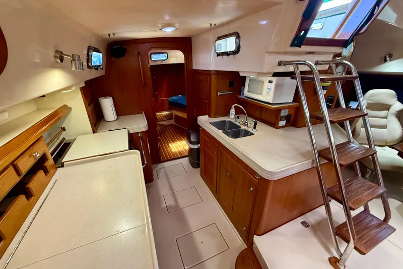 Slide: The Image of Interior of 2006 Island Packet 485 yacht with kitchen, sink, and wooden cabinetry. - 25