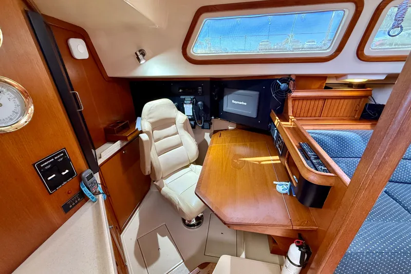 Slide: The Image of Luxurious 2006 Island Packet 485 yacht interior with navigation station and plush seating. - 28