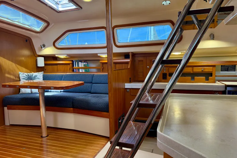 Slide: The Image of Luxurious interior of a 2006 Island Packet 485 yacht, featuring a cozy seating area and wooden accents. - 30