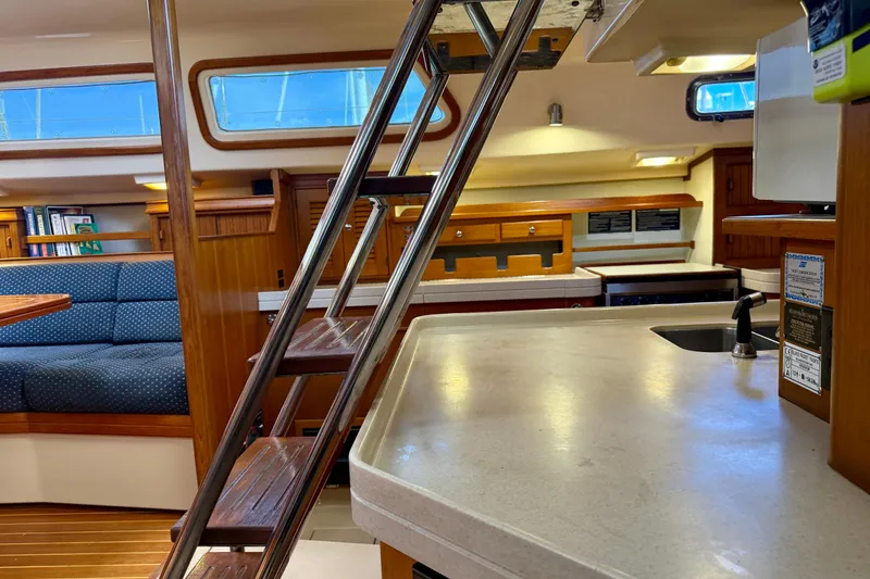 Slide: The Image of Interior of a 2006 Island Packet 485 yacht, featuring a cozy seating area and modern kitchen. - 31