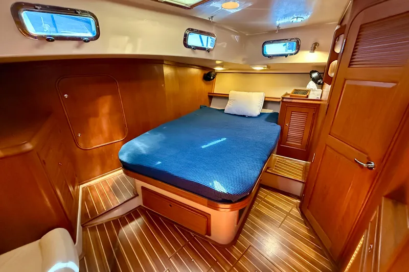 Slide: The Image of Luxurious 2006 Island Packet 485 yacht cabin with wooden interior and cozy bed. - 32
