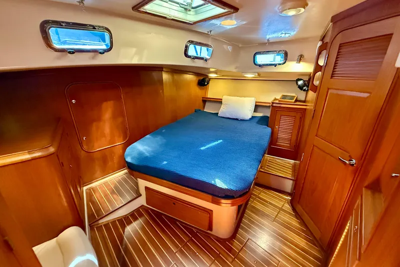 Slide: The Image of Luxurious 2006 Island Packet 485 yacht cabin with wooden interior and cozy bed. - 33