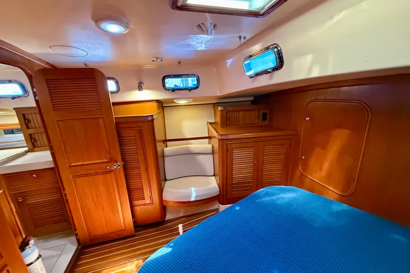 Slide: The Image of Interior of 2006 Island Packet 485 yacht with wooden cabinetry and blue bedding. - 35