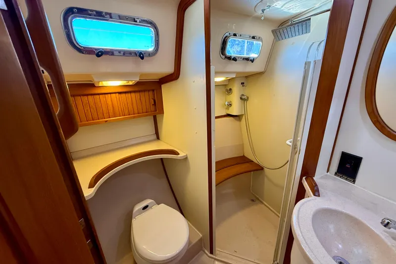 Slide: The Image of Luxurious 2006 Island Packet 485 yacht bathroom with shower, toilet, and wooden accents. - 38