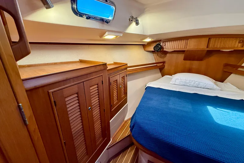 Slide: The Image of Cozy cabin interior of 2006 Island Packet 485 yacht with wooden cabinetry and blue bedding. - 40