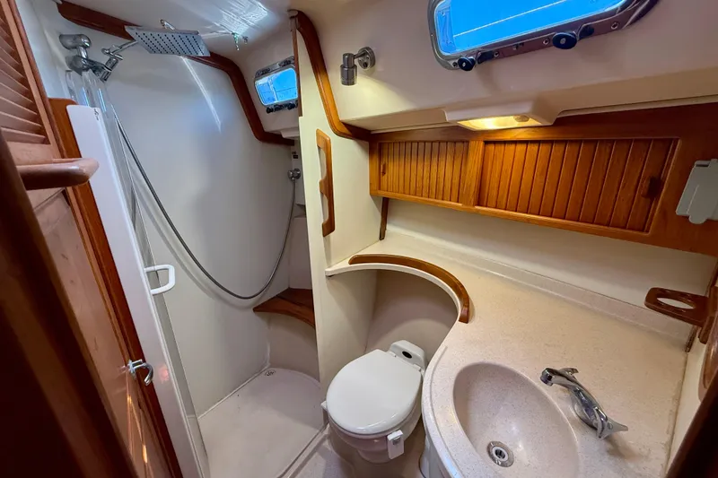 Slide: The Image of Luxurious 2006 Island Packet 485 yacht bathroom with shower, sink, and wooden cabinetry. - 42
