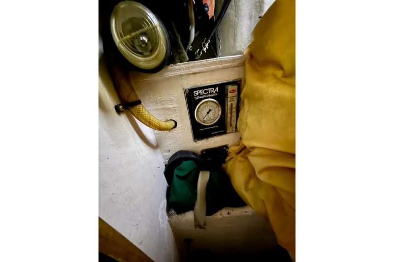 Slide: The Image of Spectra watermaker gauge on 2006 Island Packet 485 sailboat, surrounded by hoses and equipment. - 50