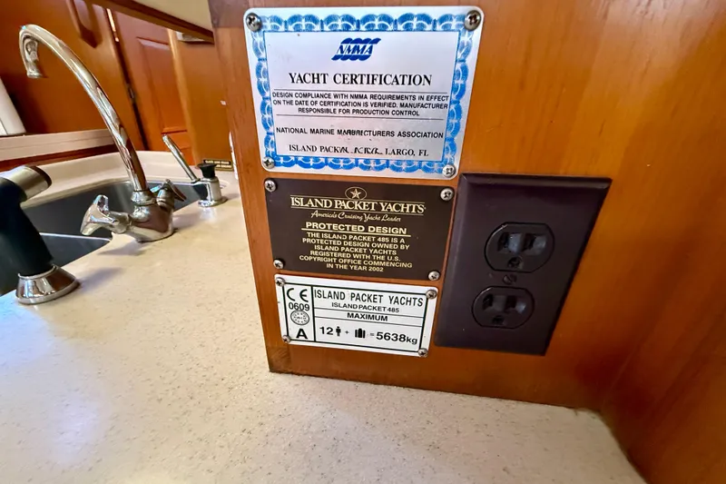 Slide: The Image of Yacht certification and design plaques on 2006 Island Packet 485, with sink and outlet nearby. - 53