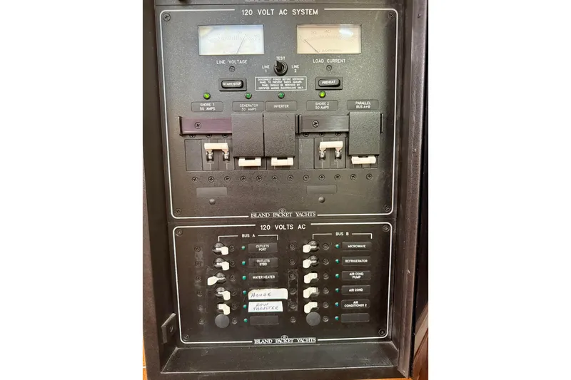 Slide: The Image of Electrical panel of a 2006 Island Packet 485 yacht, showing 120-volt AC system controls. - 54