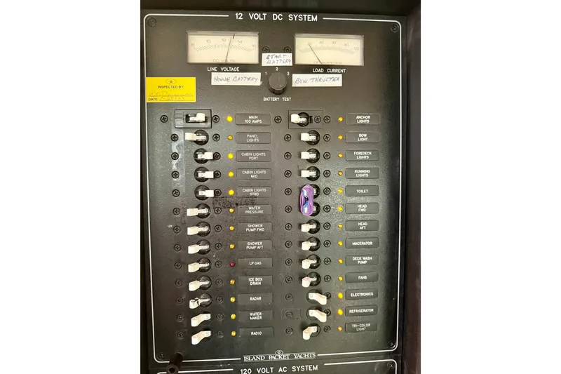 Slide: The Image of Electrical panel of a 2006 Island Packet 485 yacht, showing 12-volt DC system controls. - 55