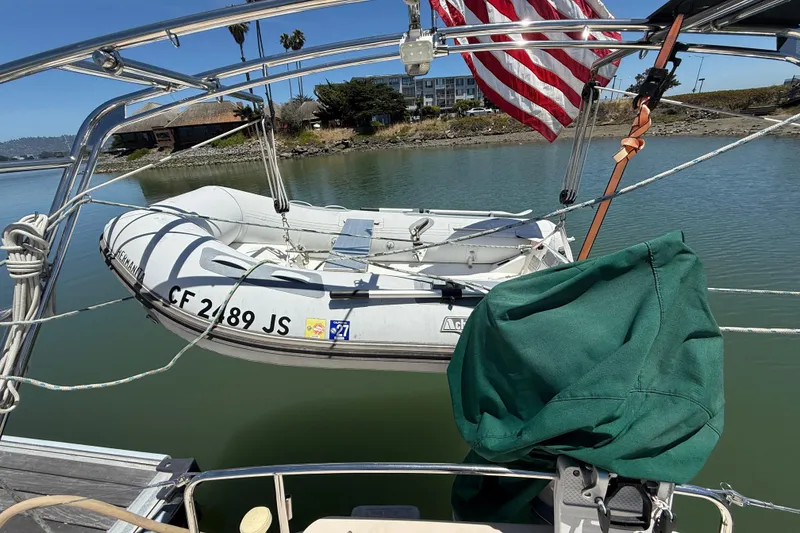 Slide: The Image of Inflatable dinghy on Island Packet 485 sailboat, 2003 model, docked by calm waters. - 59