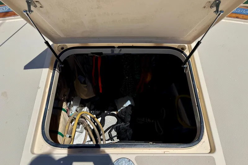 Slide: The Image of Open storage compartment on 2003 Island Packet 485 sailboat deck, containing ropes and equipment. - 60