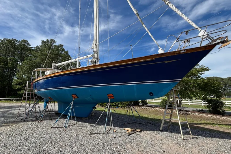 Slide: The Image of 1988 Tayana 52 sailboat on stands, blue hull, outdoors, clear sky background. - 13