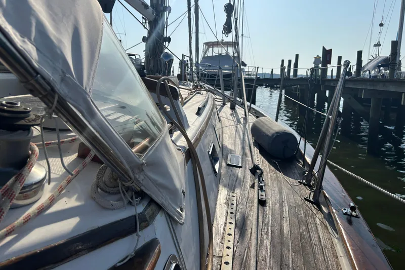 Slide: The Image of 1988 Tayana 52 sailboat docked, showcasing wooden deck and rigging details. - 36