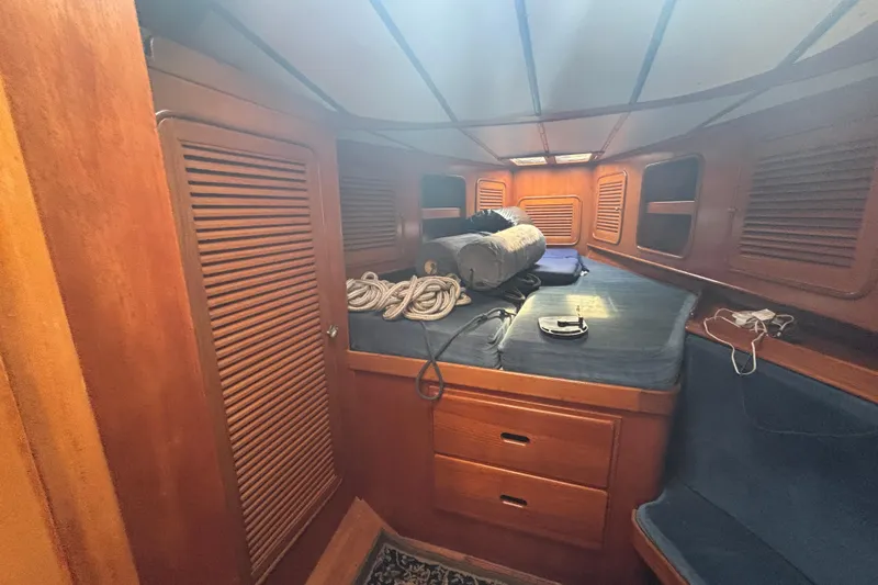 Slide: The Image of Interior cabin of 1988 Tayana 52 sailboat with wooden finish and blue cushions. - 59