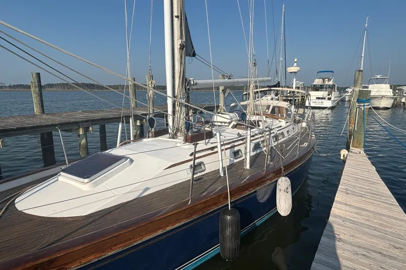 Slide: The Image of 1988 Tayana 52 sailboat docked at a marina, clear blue sky background. - 26