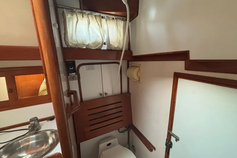 Slide: The Image of Interior of 1988 Tayana 52 sailboat bathroom with wooden accents and stainless steel sink. - 44