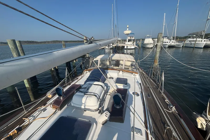 Slide: The Image of 1988 Tayana 52 sailboat docked at marina, clear sky, calm waters. - 39