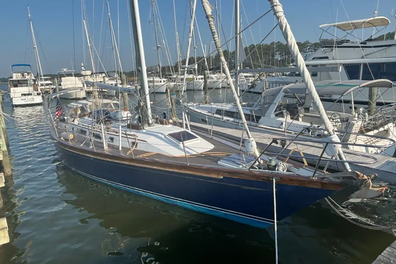 The Image of 1988 Tayana 52 sailboat docked at a marina, surrounded by other boats. - 22