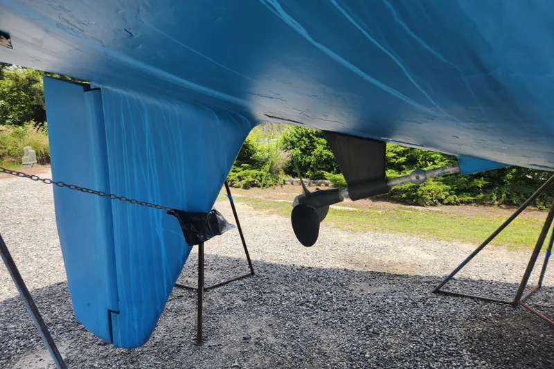 Slide: The Image of 1988 Tayana 52 sailboat hull and propeller, displayed on stands outdoors. - 6