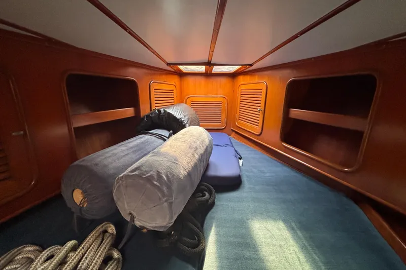 Slide: The Image of Interior cabin of 1988 Tayana 52 sailboat with wooden shelves and blue carpet. - 60