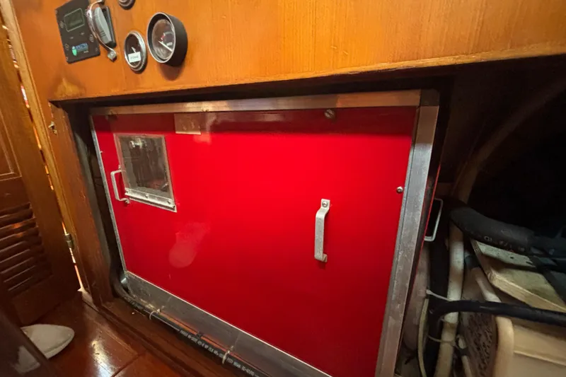 Slide: The Image of Engine compartment of a 1988 Tayana 52 sailboat with red panel and gauges. - 65