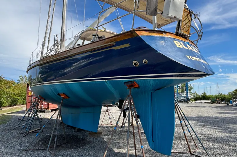 Slide: The Image of 1988 Tayana 52 sailboat on stands, blue hull, outdoor setting. - 9