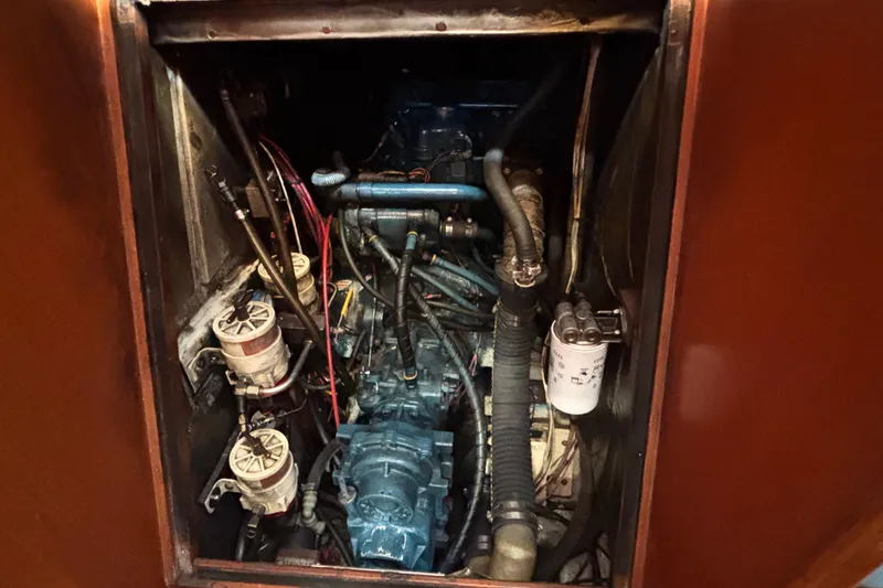 Slide: The Image of Engine compartment of a 1988 Tayana 52 sailboat, showcasing mechanical components and wiring. - 67