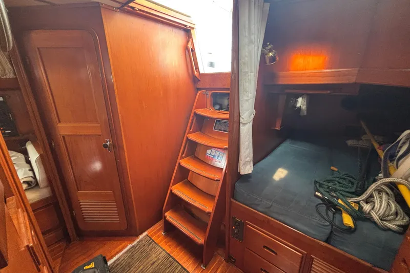 Slide: The Image of Interior of 1988 Tayana 52 sailboat with wooden cabinetry and cozy sleeping area. - 41