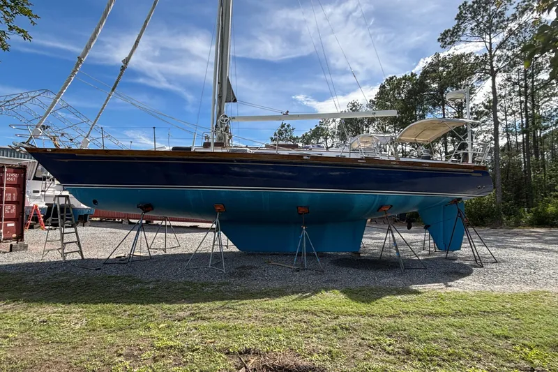 Slide: The Image of 1988 Tayana 52 sailboat on stands, blue hull, outdoors, sunny day. - 10